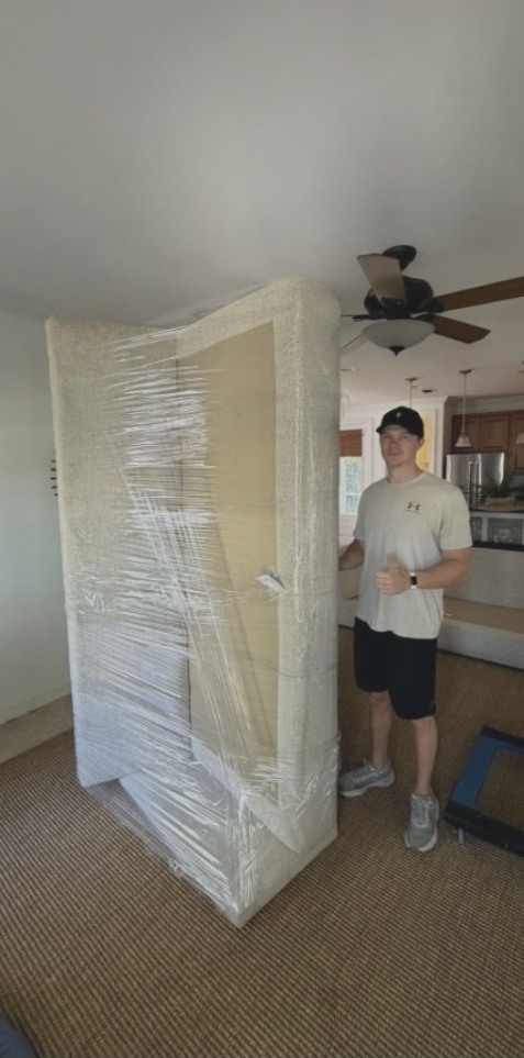 Lorin Helfenstein helping move a carefully wrapped piece of furniture